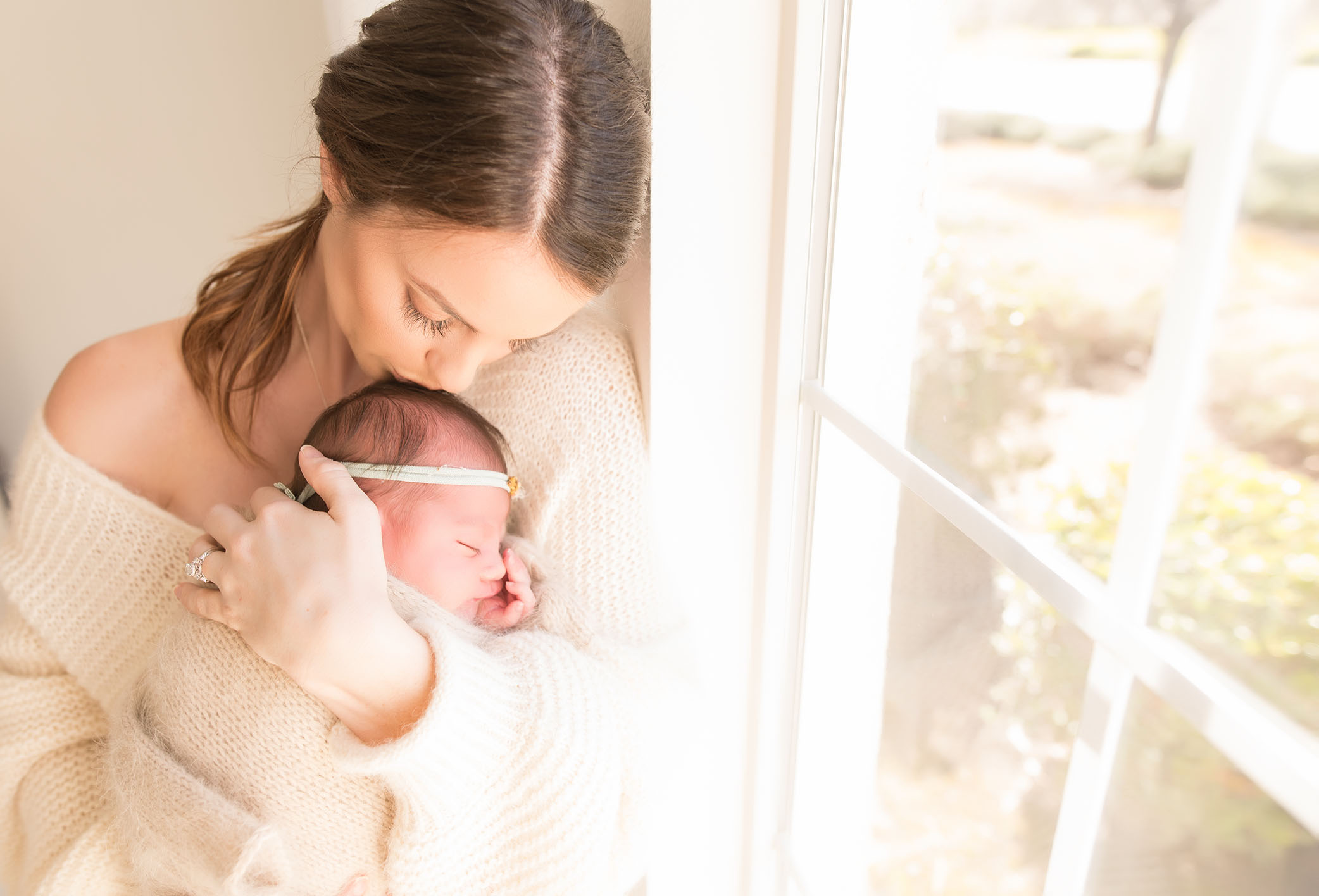 A baby is cradled by her mother | Sacramento Newborn And Family Photography
