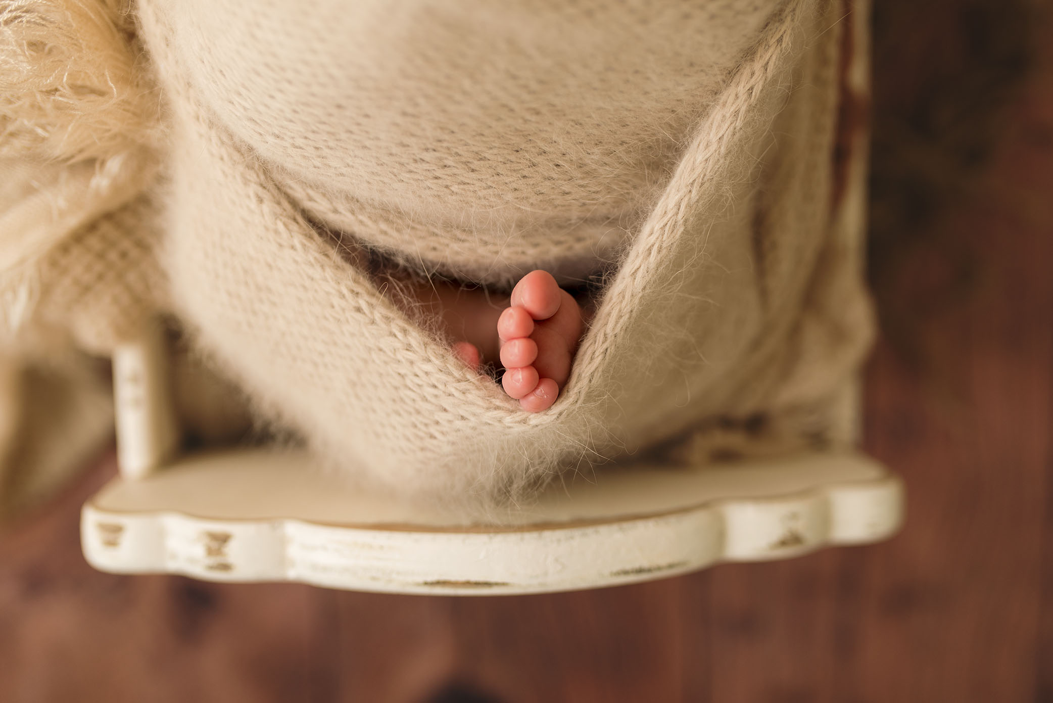 A newborn's foot peeks out of a blanket. 
