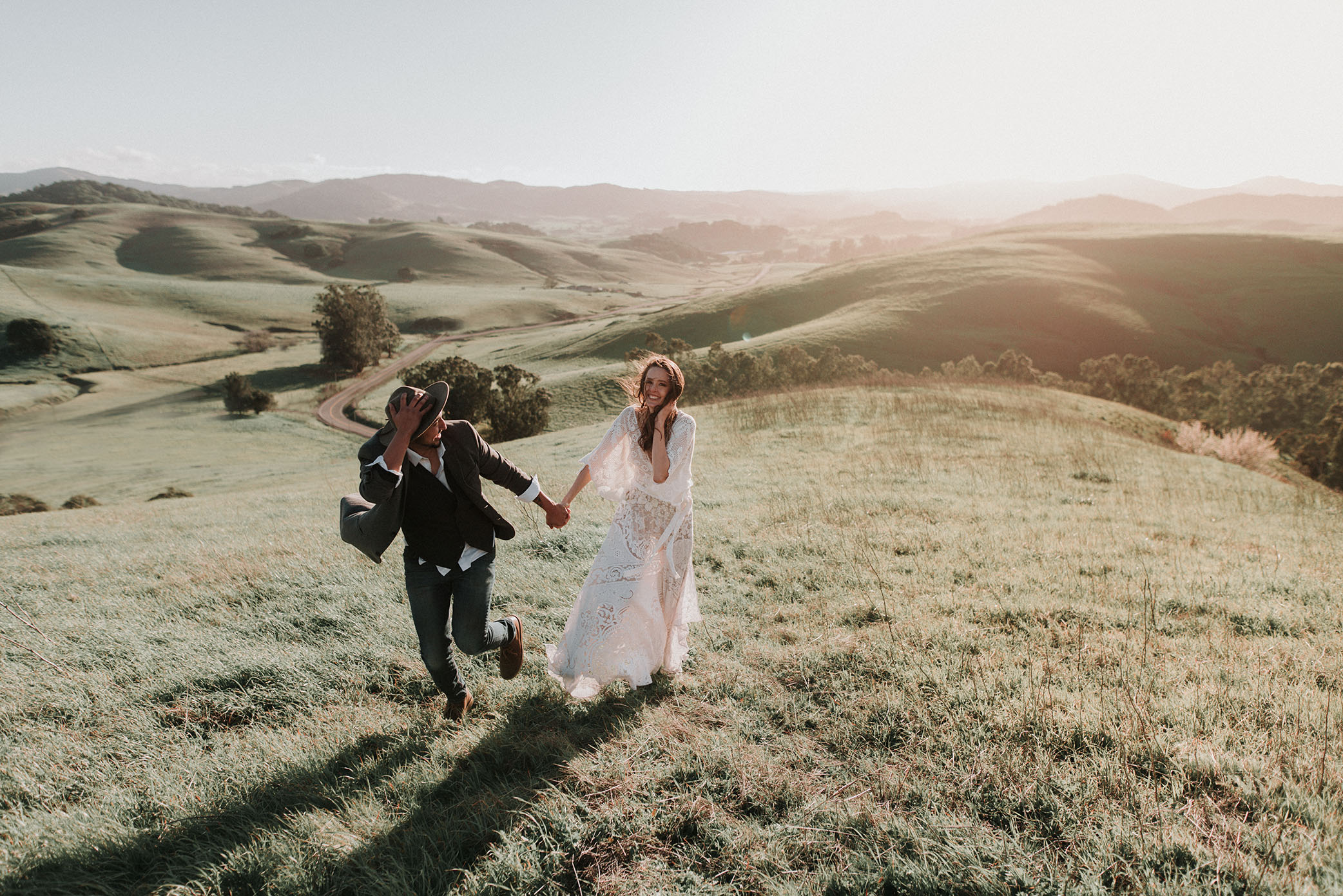 A couple walks in a field together