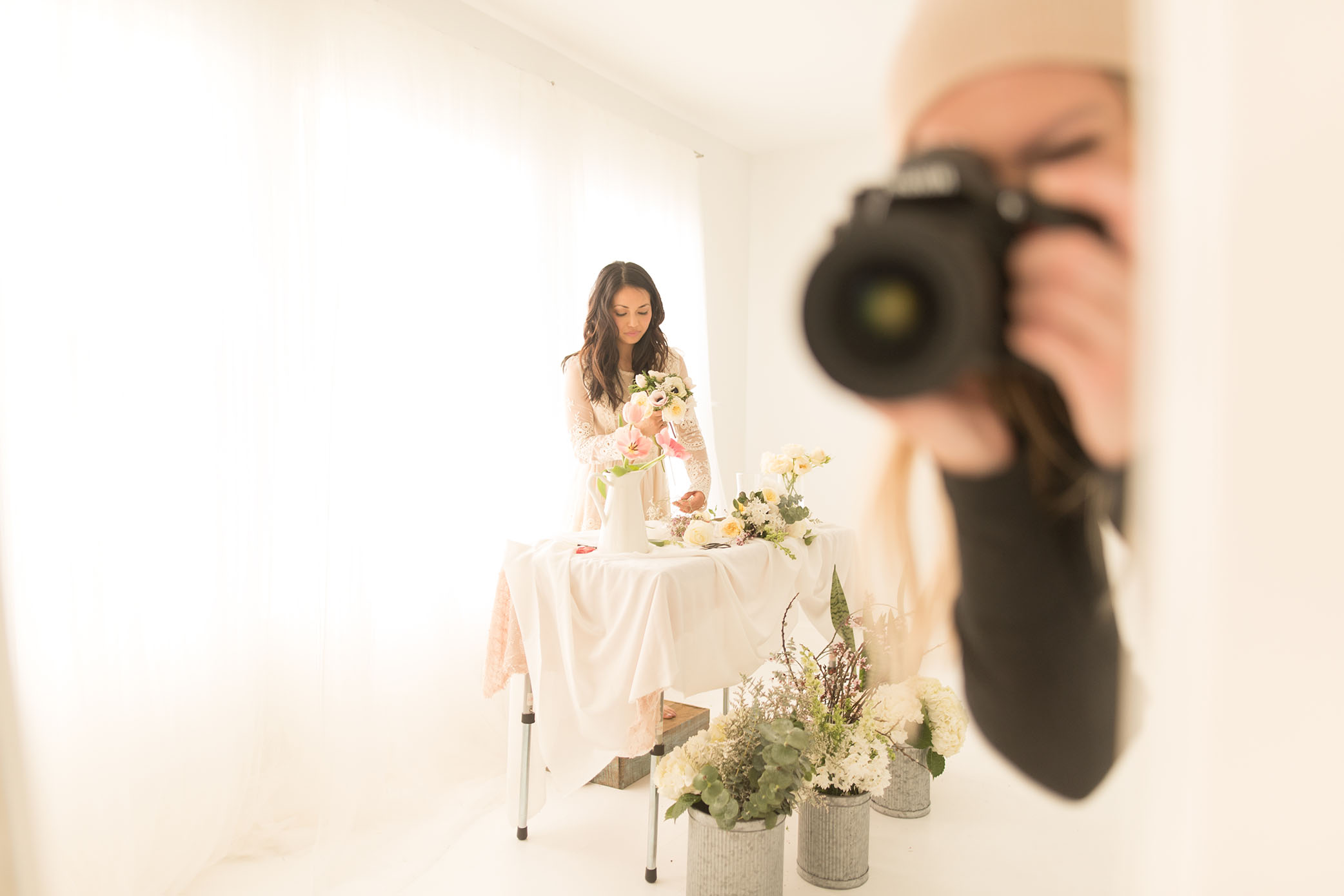 A photographer captures a woman arranging flowers. 