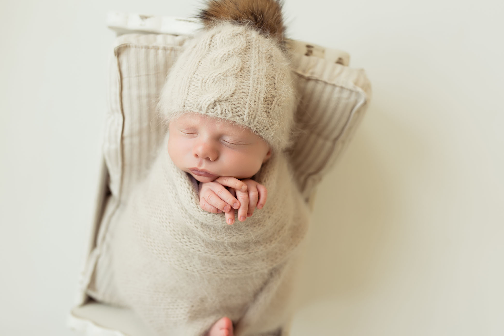 Newborn posed on striped mattress captured by Sweet Beginnings Photography by Stephanie