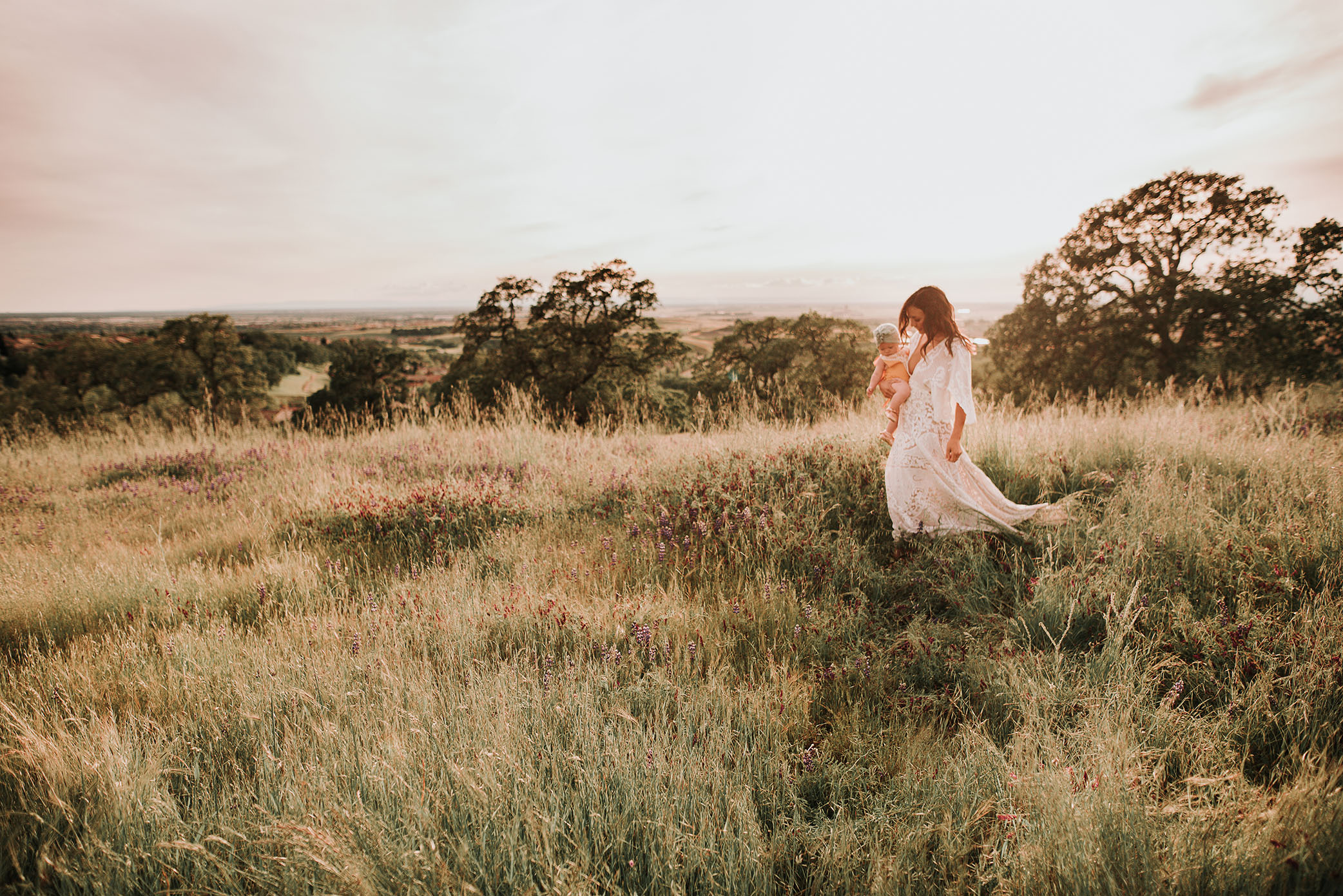 Mom looking ethereal while walking on grassy hill captured by Sweet Beginnings Photography by Stephanie 