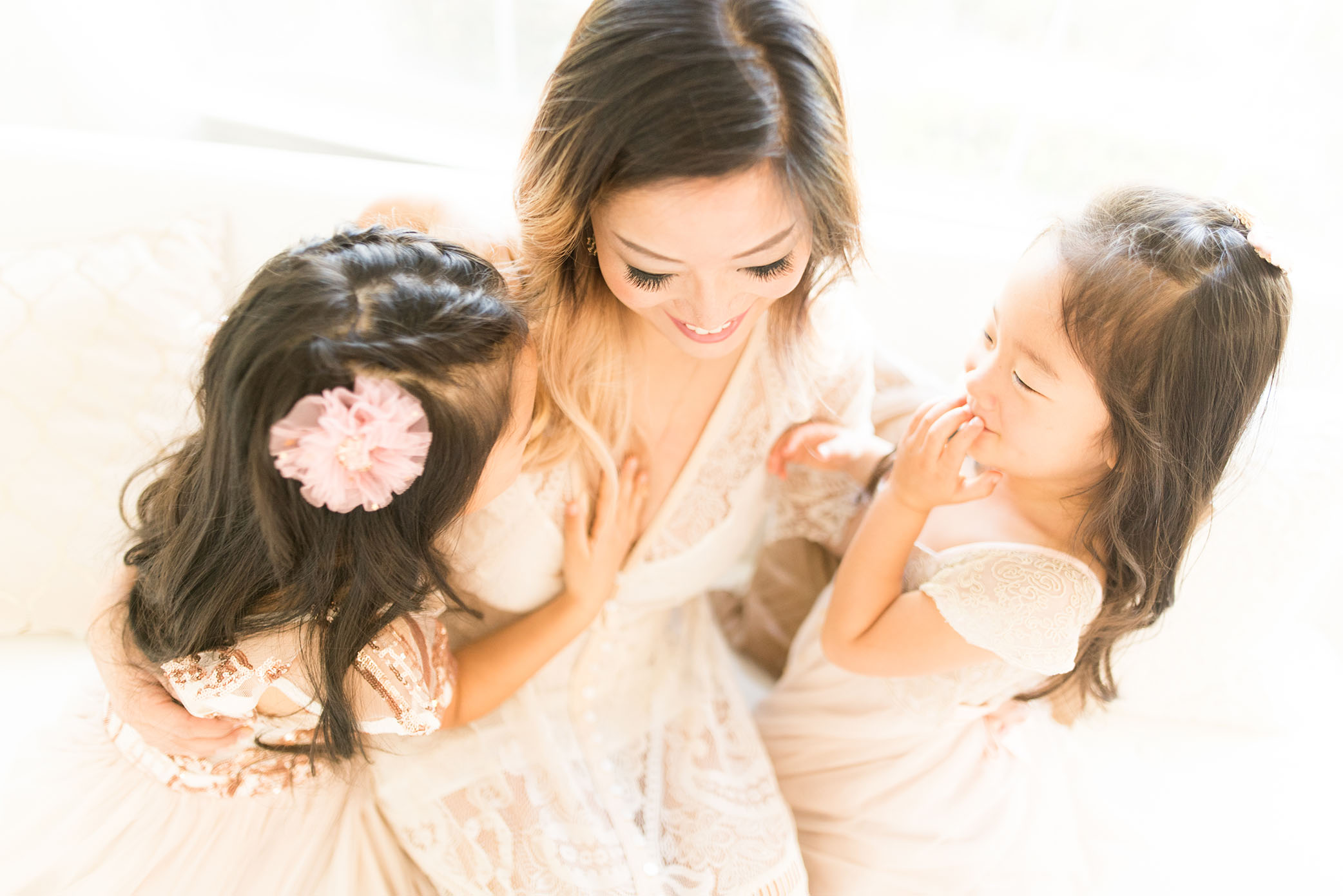 A mother sits with young daughters captured by Sweet Beginnings Photography by Stephanie
