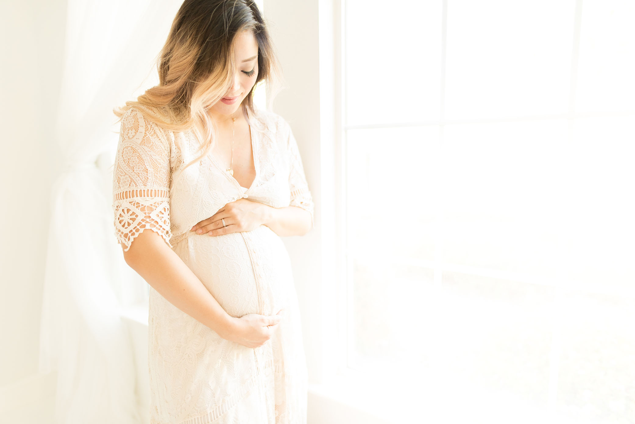 A pregnant mom looking down at her belly captured by Sweet Beginnings Photography by Stephanie