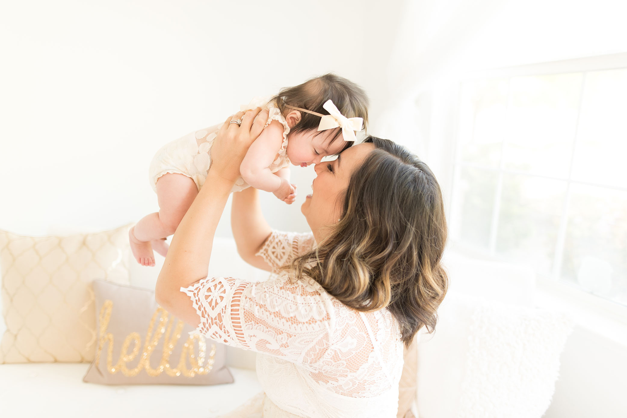 Mom holds baby up in the air for a kiss captured by Sweet Beginnings Photography by Stephanie