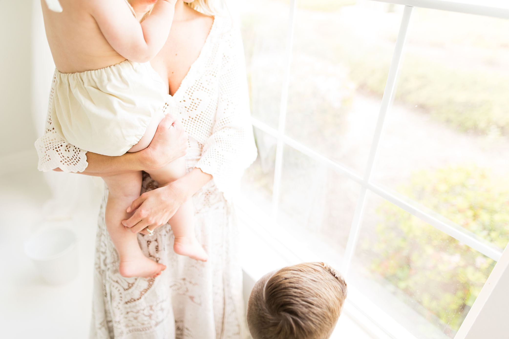 Mom and kids hang by the window in the studio captured by Sweet Beginnings Photography by Stephanie