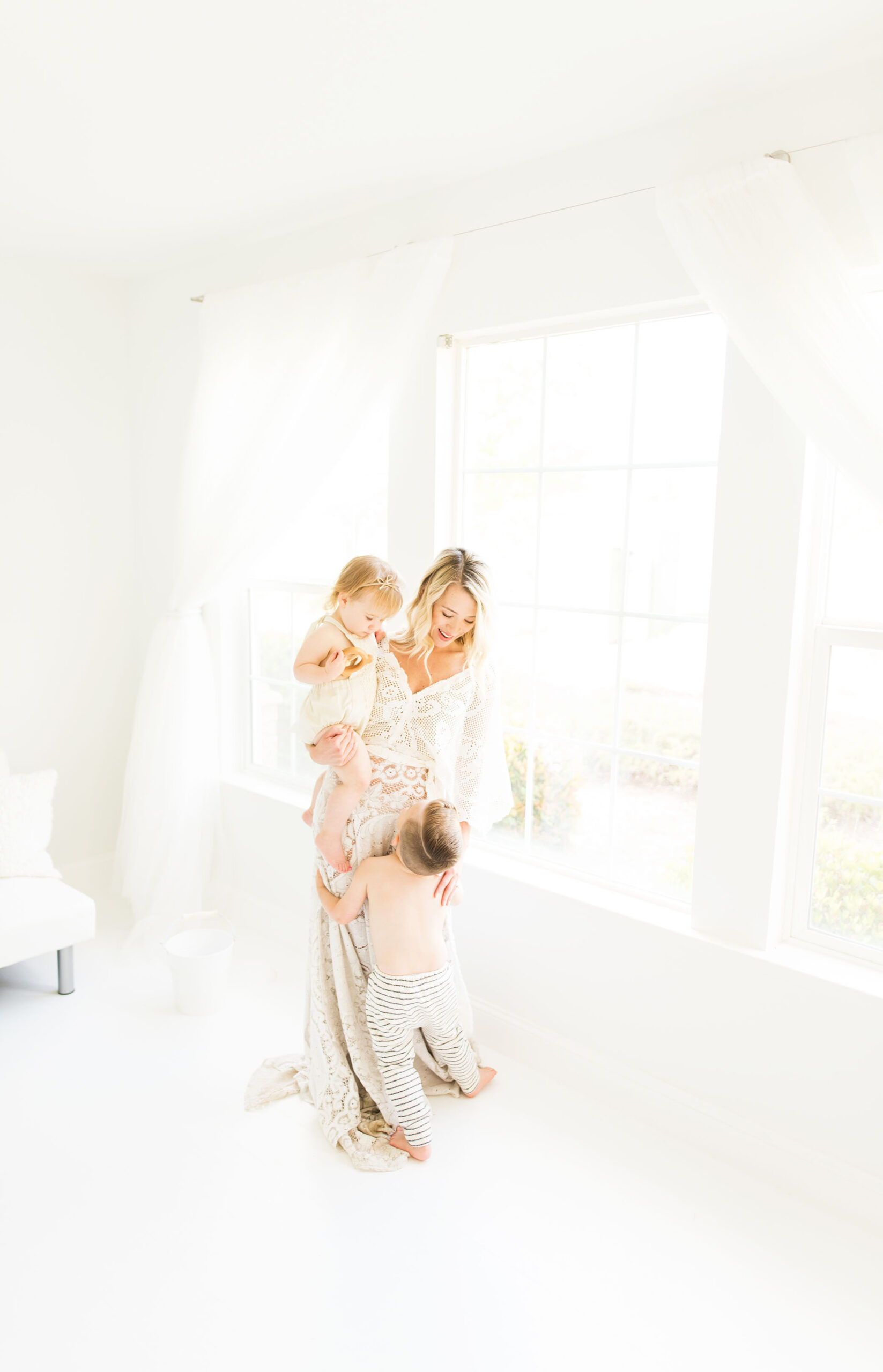 Mom, daughter and son in the studio wearing white captured by Sweet Beginnings Photography by Stephanie