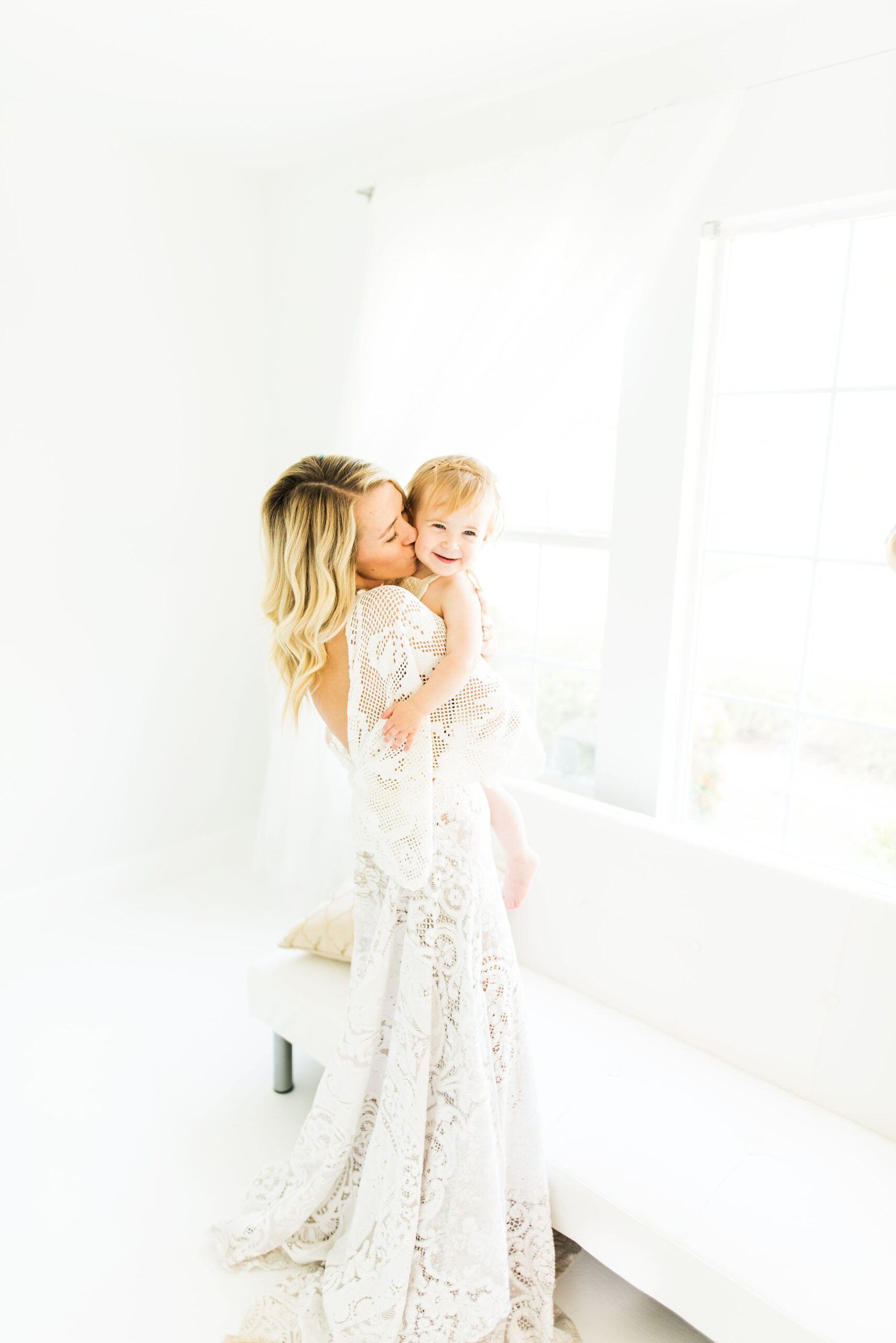 Mom hugs baby in the studio captured by Sweet Beginnings Photography by Stephanie