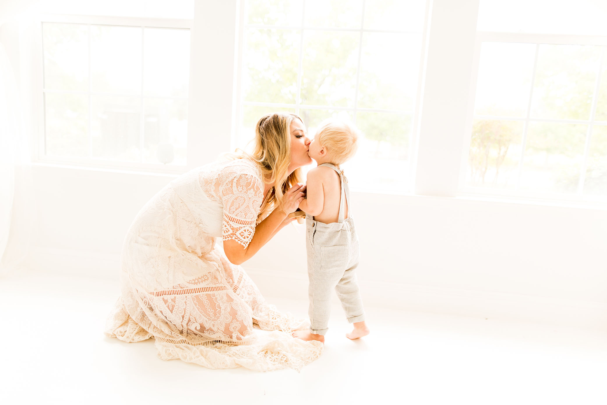 Mom steals kisses from son captured by Sweet Beginnings Photography by Stephanie
