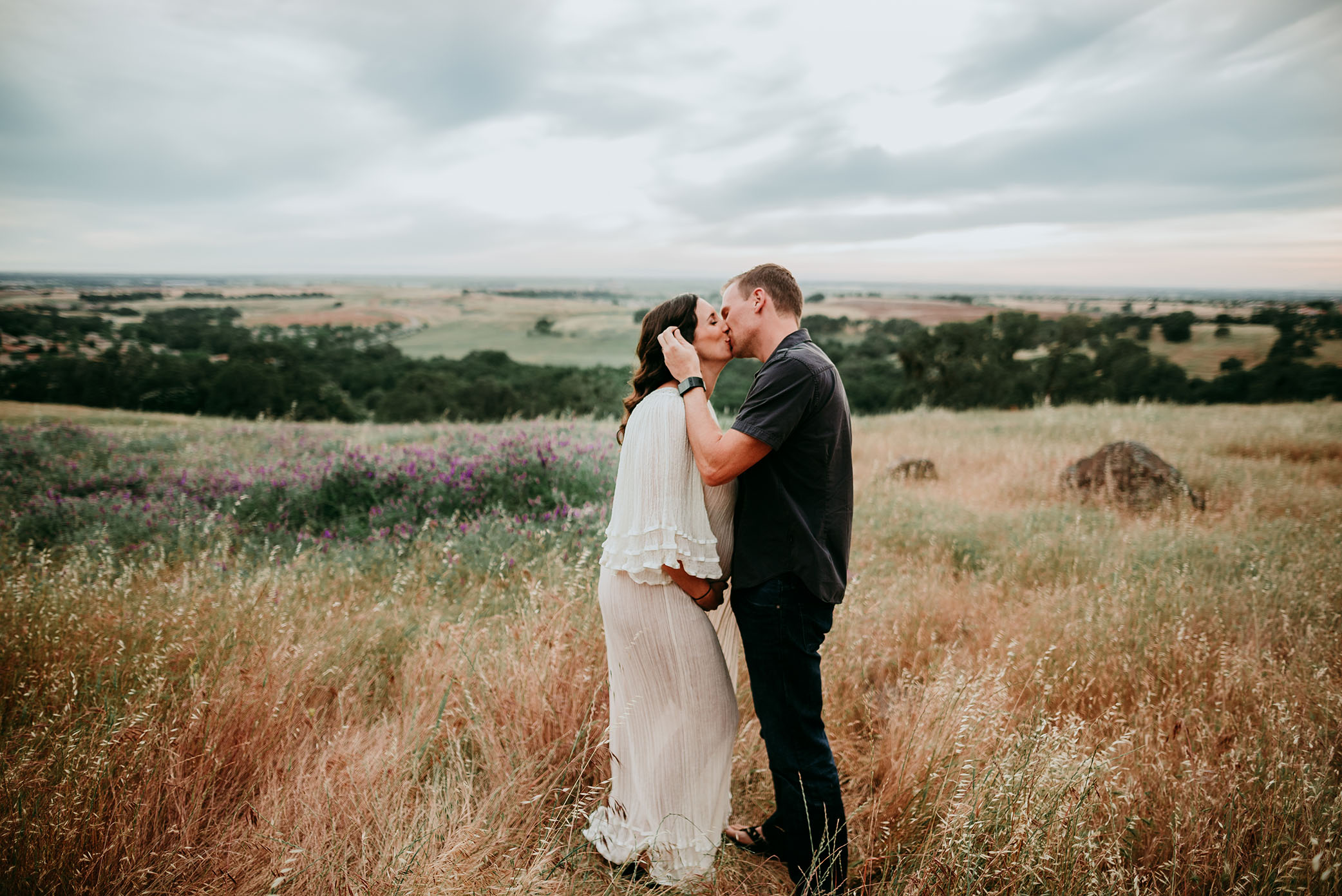 A maternity kiss before sunset captured by Sweet Beginnings Photography by Stephanie